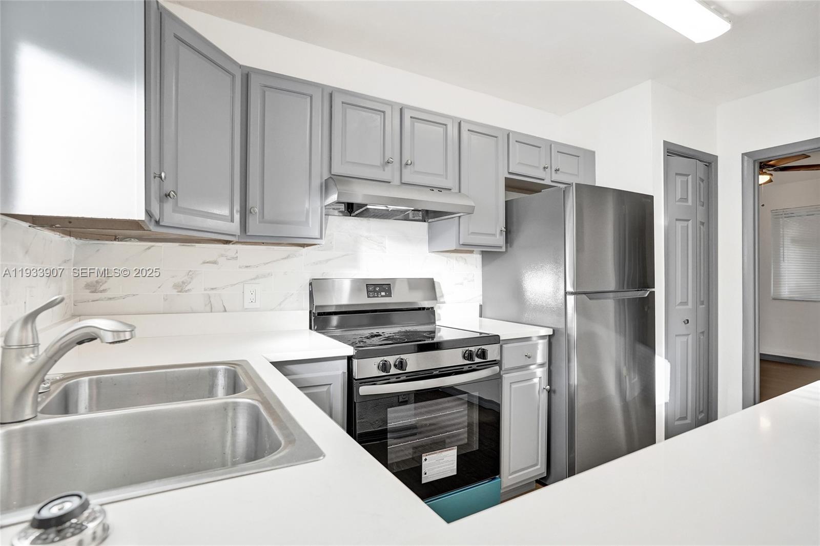 249 Southwest 4th Street, Unit 2 Dania Beach, FL 33004 - Photo 4 of 26 a kitchen with cabinets and stainless steel appliances