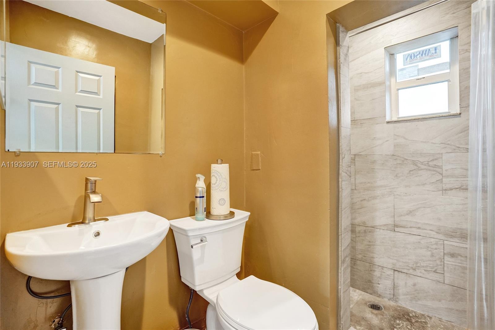 249 Southwest 4th Street, Unit 2 Dania Beach, FL 33004 - Photo 9 of 26 a bathroom with a sink a toilet and mirror