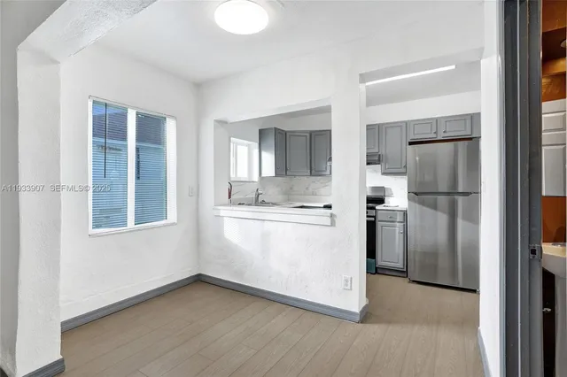 a view of kitchen with refrigerator and window