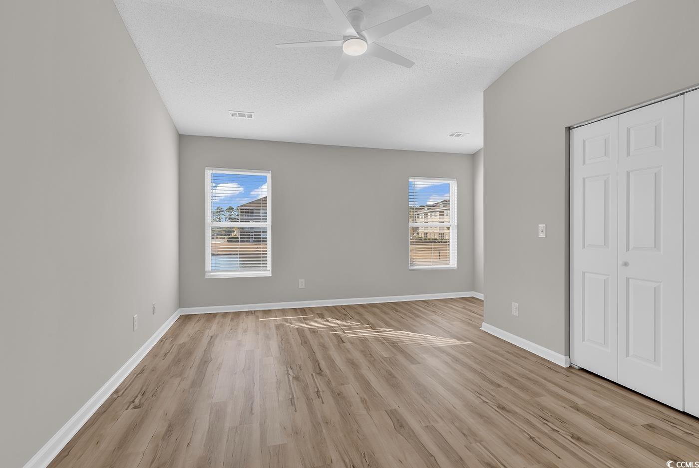 308 Kiskadee Loop, Unit E Conway, SC 29526 - Photo 20 of 36 Unfurnished bedroom featuring a closet, light wood-style flooring, a ceiling fan, and a textured ceiling