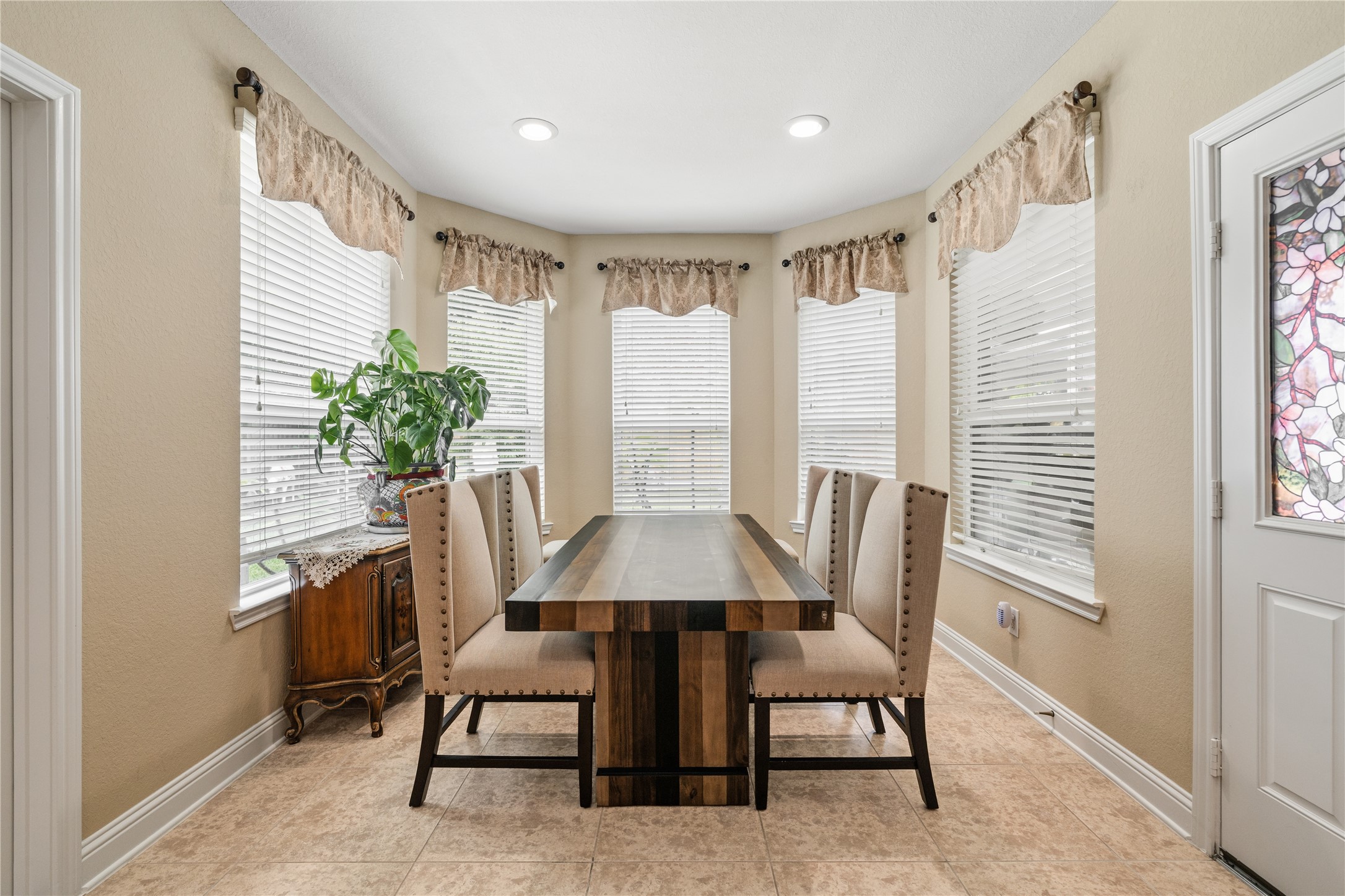 5802 Layton Meadows Lane Spring, TX 77379 - Photo 17 of 42 Breakfast nook second angle. Straight-on view showing the full bay window wall, symmetrical curtains, and the stained glass door clearly.