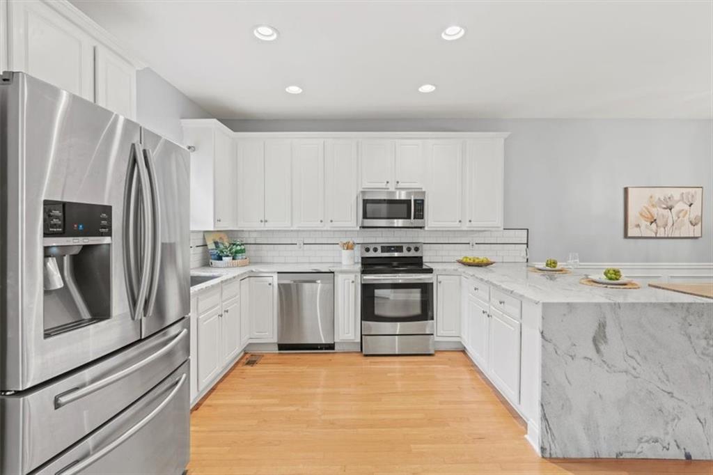 1200 Wing Street, Unit 8 Atlanta, GA 30350 - Photo 12 of 54 a kitchen with white cabinets and stainless steel appliances
