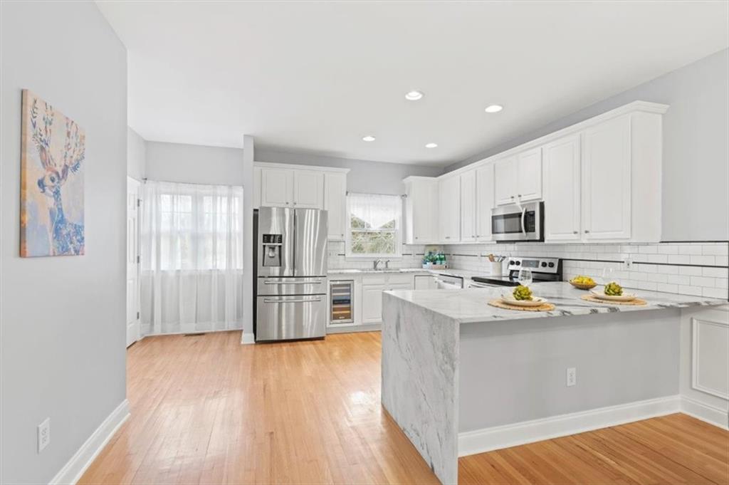 1200 Wing Street, Unit 8 Atlanta, GA 30350 - Photo 2 of 54 a kitchen with stainless steel appliances granite countertop a refrigerator oven a sink dishwasher and white cabinets with wooden floor