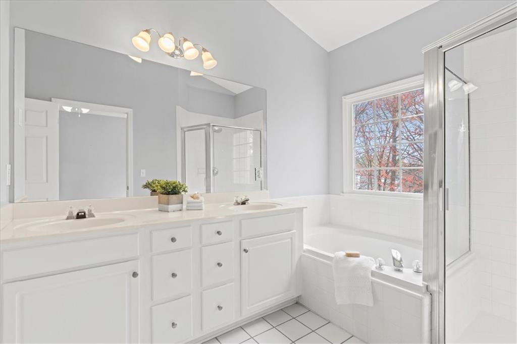 1200 Wing Street, Unit 8 Atlanta, GA 30350 - Photo 21 of 54 a spacious bathroom with a double vanity sink a large mirror a bathtub and window