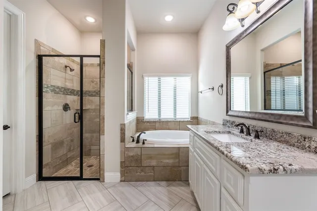 a bathroom with a tub a sink and mirror