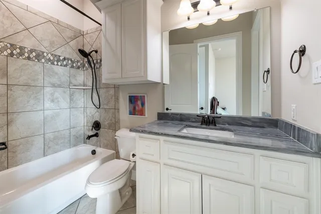 a bathroom with a sink and mirror with bathtub