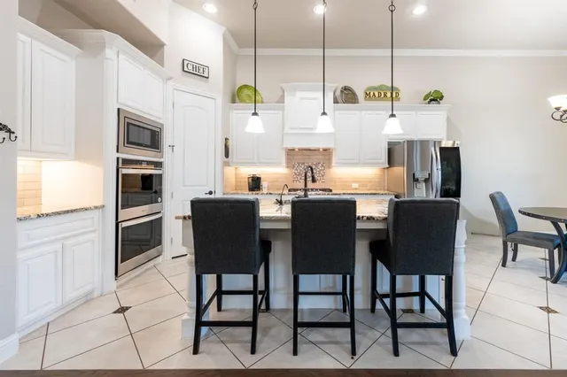 a kitchen with stainless steel appliances kitchen island granite countertop a table and chairs