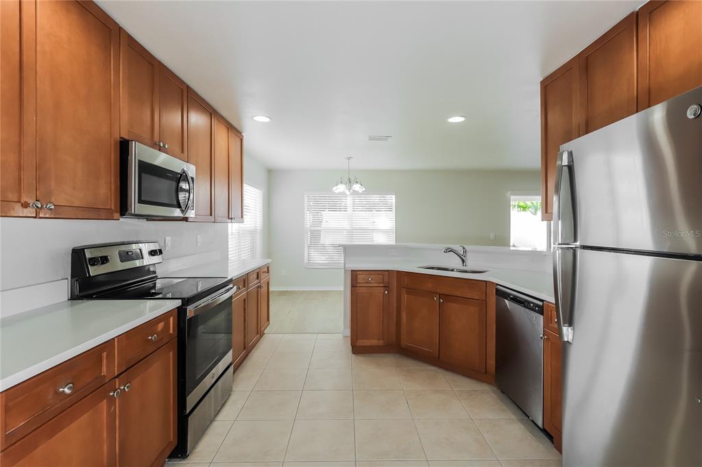 11420 Bay Gardens Loop Riverview, FL 33569 - Photo 6 of 17 a kitchen with stainless steel appliances granite countertop a refrigerator stove a sink dishwasher and microwave