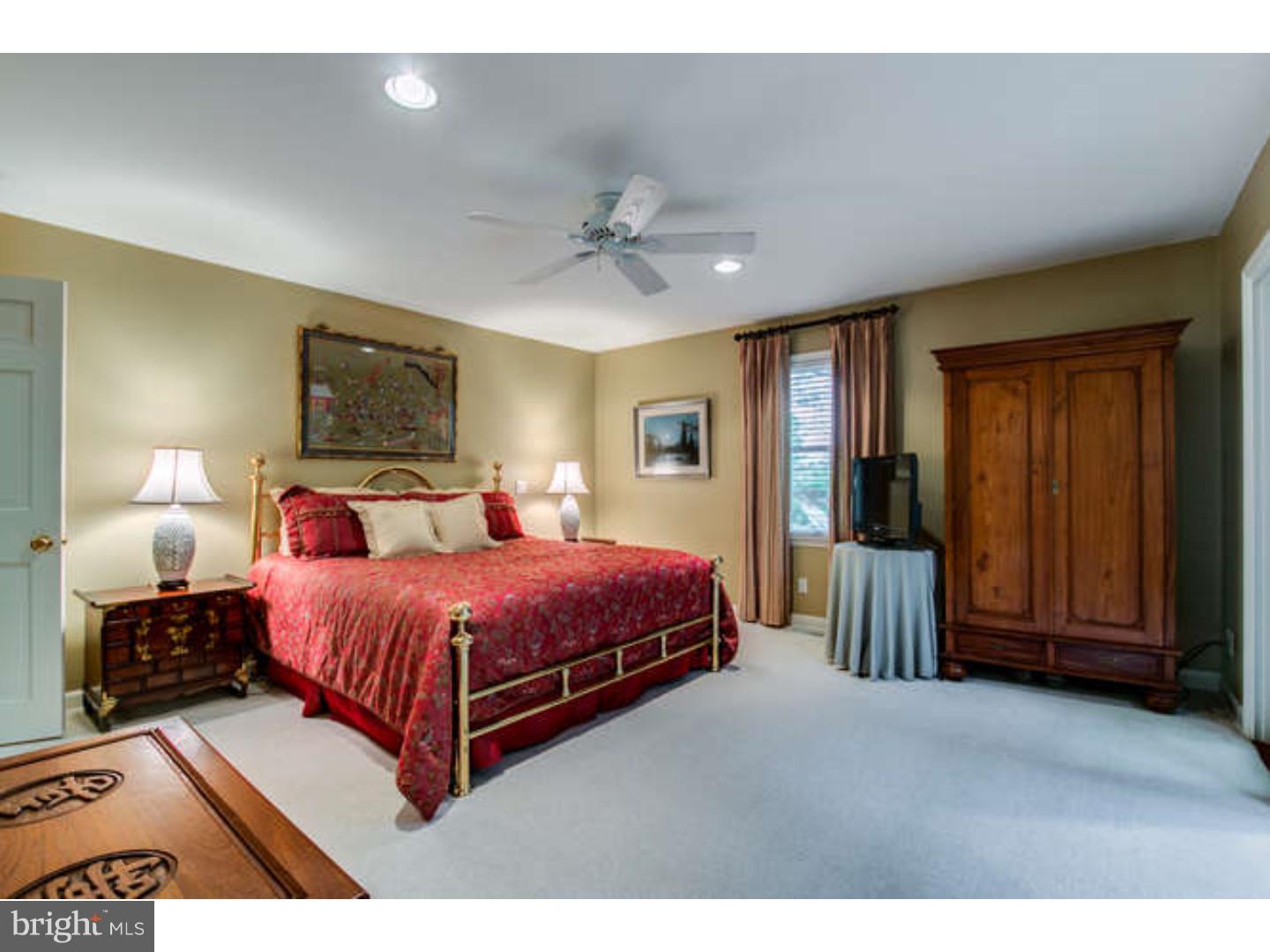 8 Squirrel Run Greenville, DE 19807 - Photo 15 of 24 a spacious bedroom with a large bed and a chandelier