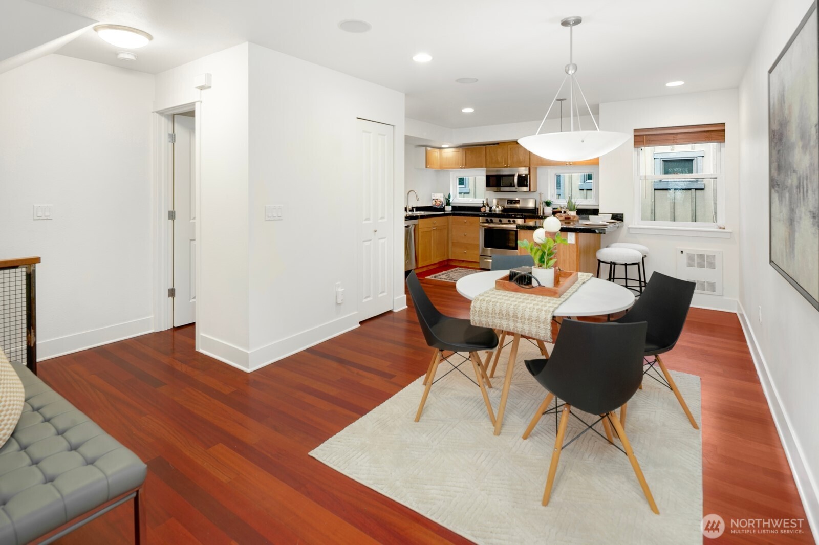 921 North 35th Street, Unit B Seattle, WA 98103 - Photo 5 of 28 an open kitchen with dining table and wooden floors