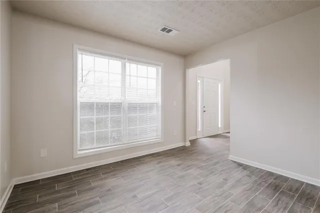 an empty room with wooden floor and window