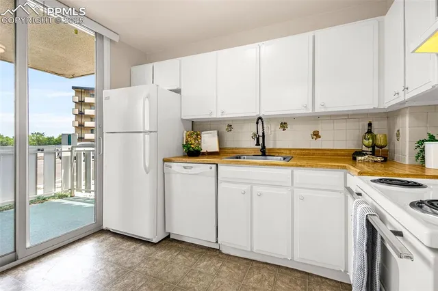 a kitchen with white cabinets and white appliances