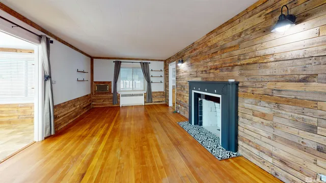 a view of a living room with stainless steel appliances wooden floor and a large window