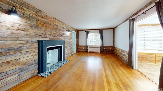 a view of empty room with wooden floor and floor to ceiling window