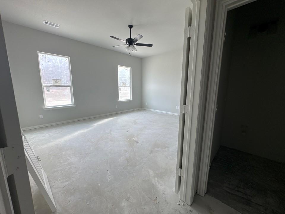 152 Oak Grv Way Springtown, TX 76082 - Photo 8 of 10 Unfurnished bedroom featuring concrete flooring and a ceiling fan