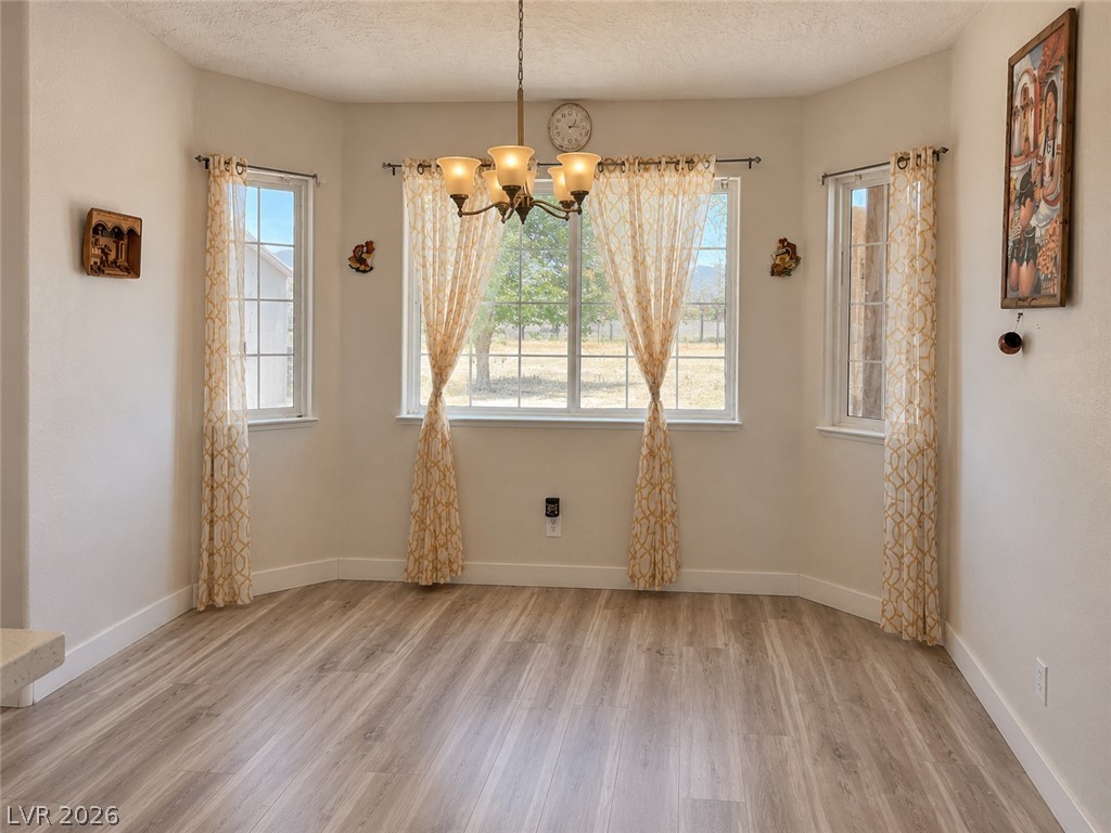 200 East Gamebird Road Pahrump, NV 89048 - Photo 9 of 23 Natural light floods this dining area through multiple windows, illuminating the durable flooring.