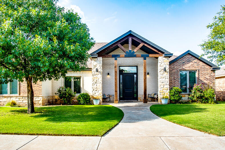 a front view of a house with a yard and potted plants