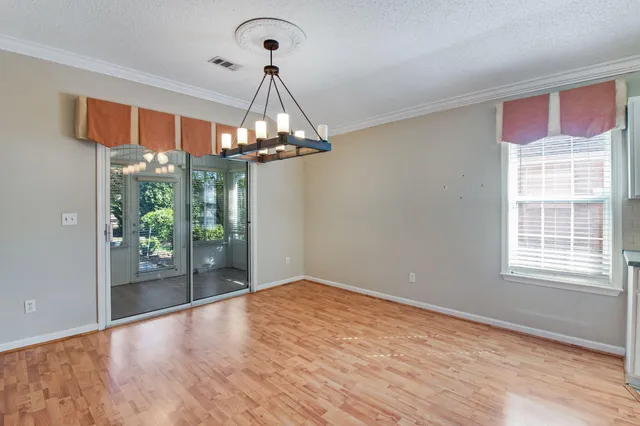 a view of a livingroom with a chandelier wooden floor and chandelier