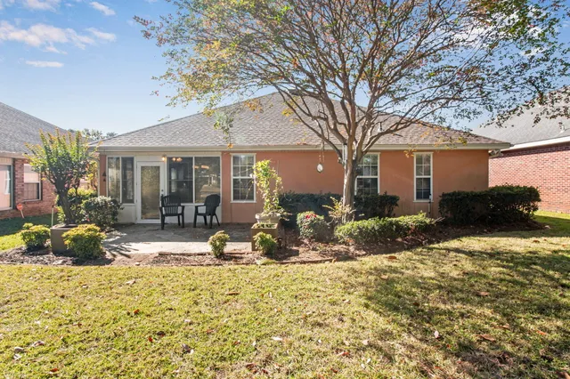 a view of a house with backyard sitting area and garden