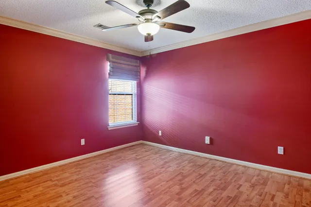 a view of a big room with window and ceiling fan