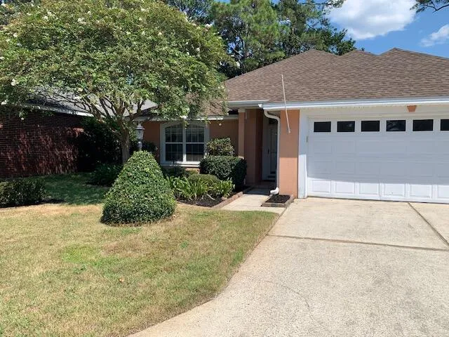 a view of a house with a yard and potted plants