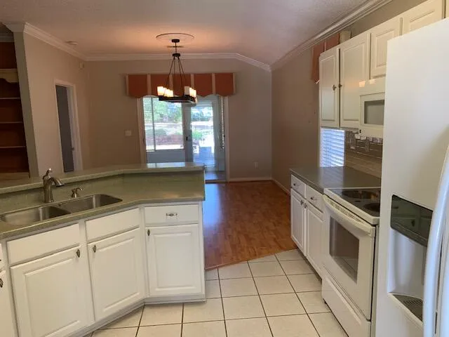 a kitchen with granite countertop white cabinets and white appliances