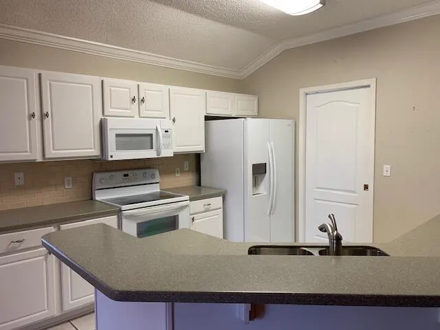 a kitchen with appliances a sink and cabinets