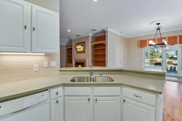 a kitchen with granite countertop a sink stainless steel appliances white cabinets and a granite counter tops
