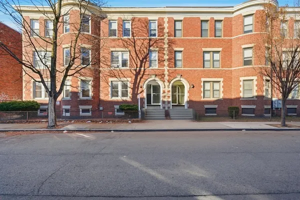 a front view of a residential apartment building with a yard