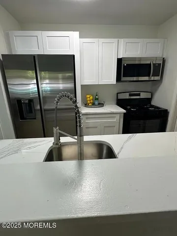 a kitchen with a refrigerator a stove a microwave and cabinets