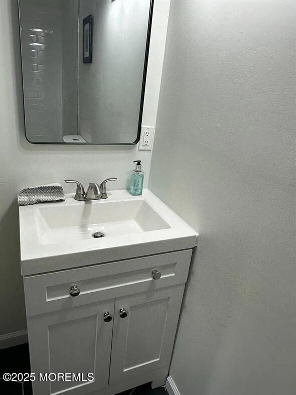 28 Delavan Court New Brunswick, NJ 08901 - Photo 9 of 10 a bathroom with a sink a mirror and vanity