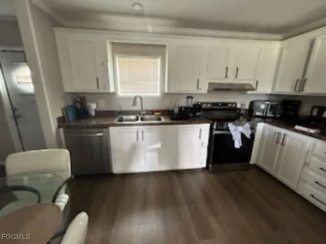 a kitchen with stainless steel appliances a sink a stove a refrigerator a microwave a sink and cabinets