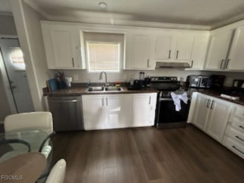 651 Hunting Club Avenue Clewiston, FL 33440 - Photo 2 of 9 a kitchen with stainless steel appliances a sink a stove a refrigerator a microwave a sink and cabinets