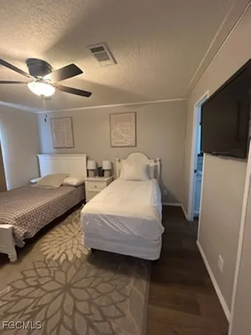 a bedroom with double bed and a flat tv screen on dresser