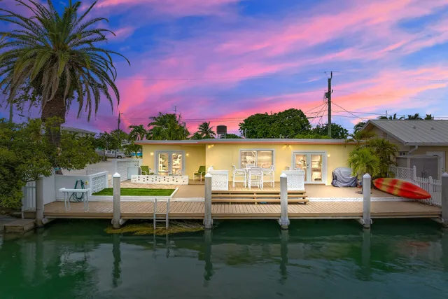 a view of a house with pool and chairs