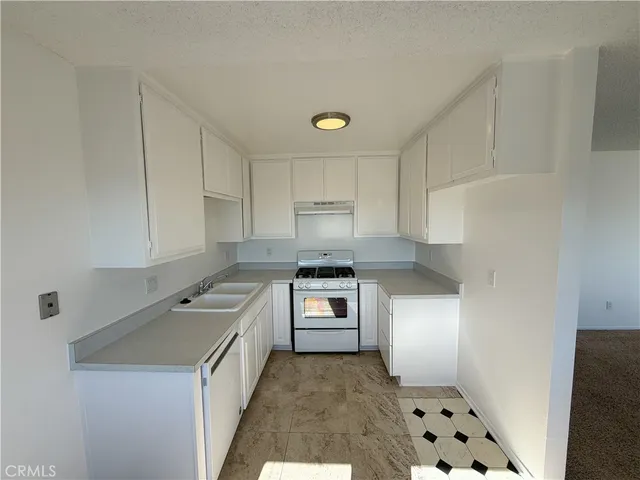 a view of a kitchen with refrigerator and wooden floor