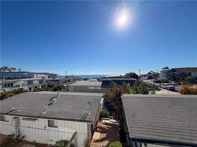 a view of a big room with windows and chandelier fan