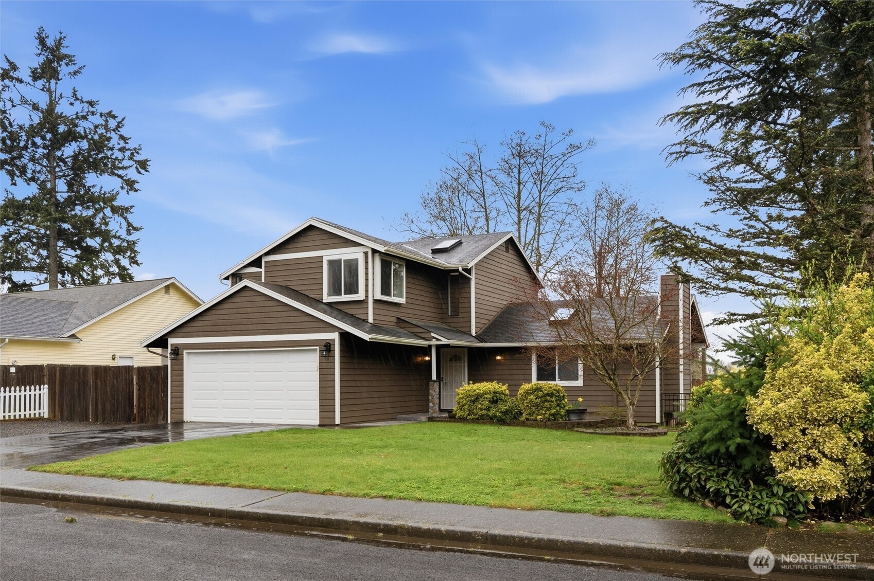 19855 Stavanger Loop Northeast Poulsbo, WA 98370 - Photo 1 of 37 a front view of a house with a yard and garage