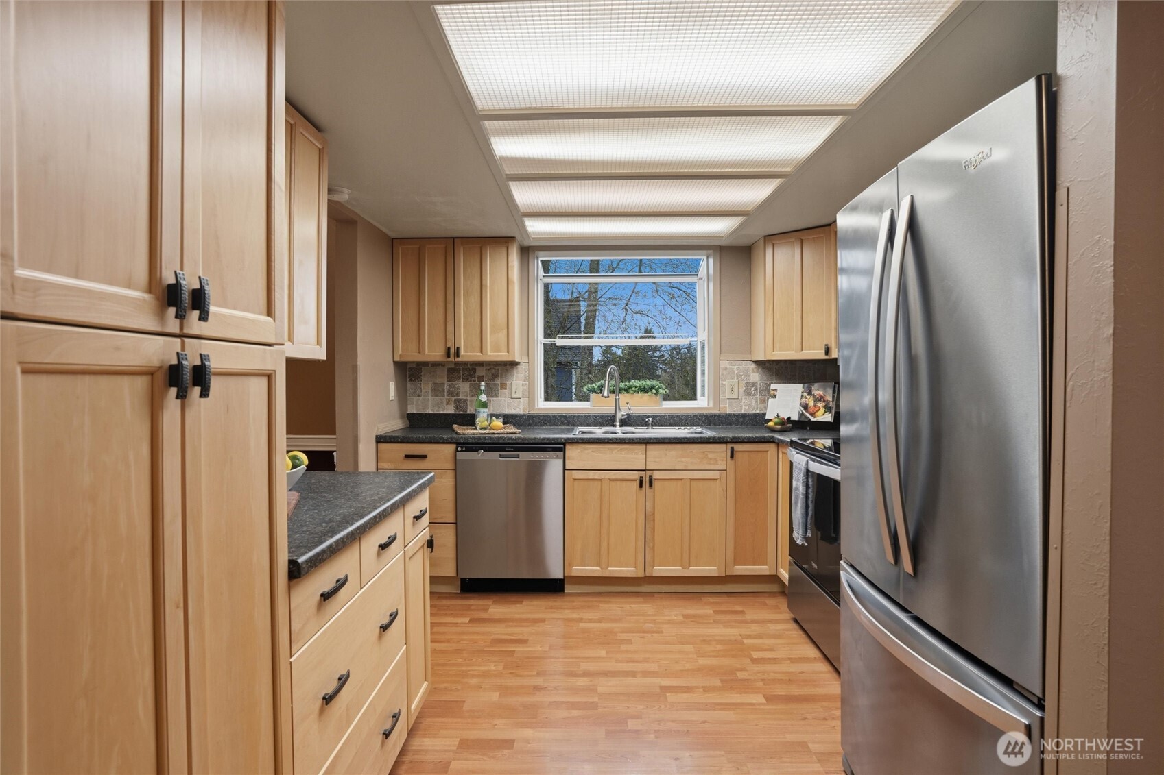 19855 Stavanger Loop Northeast Poulsbo, WA 98370 - Photo 11 of 37 a kitchen with granite countertop a refrigerator and a sink