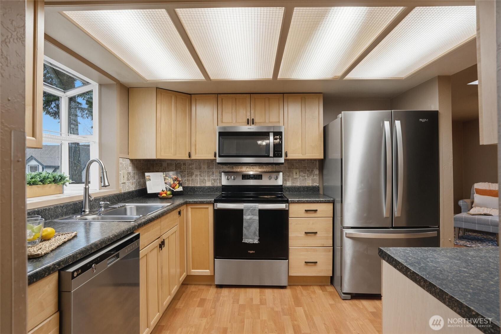 19855 Stavanger Loop Northeast Poulsbo, WA 98370 - Photo 12 of 37 a kitchen with stainless steel appliances granite countertop a sink stove microwave and refrigerator