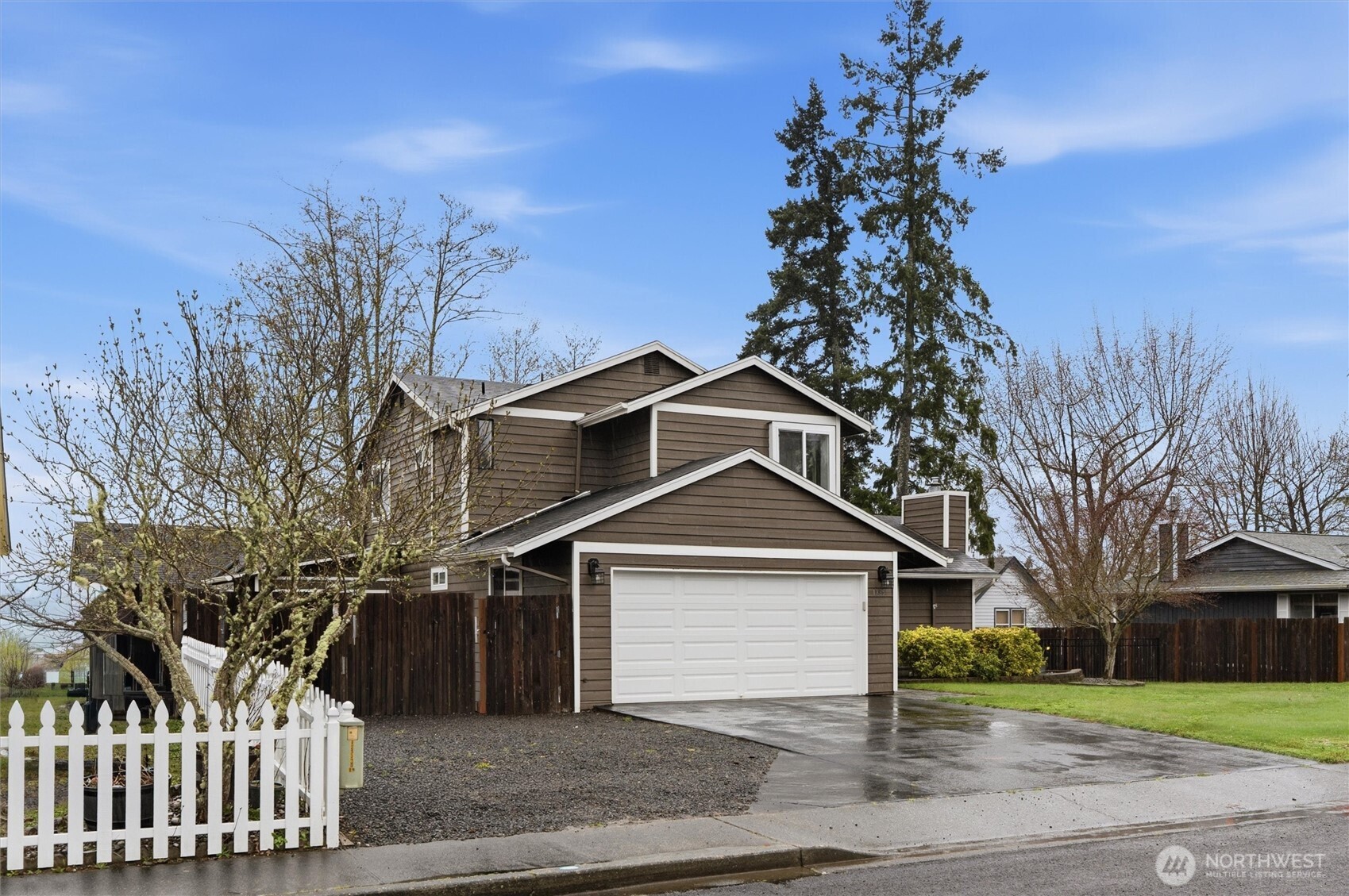 19855 Stavanger Loop Northeast Poulsbo, WA 98370 - Photo 3 of 37 a front view of a house with a yard and trees