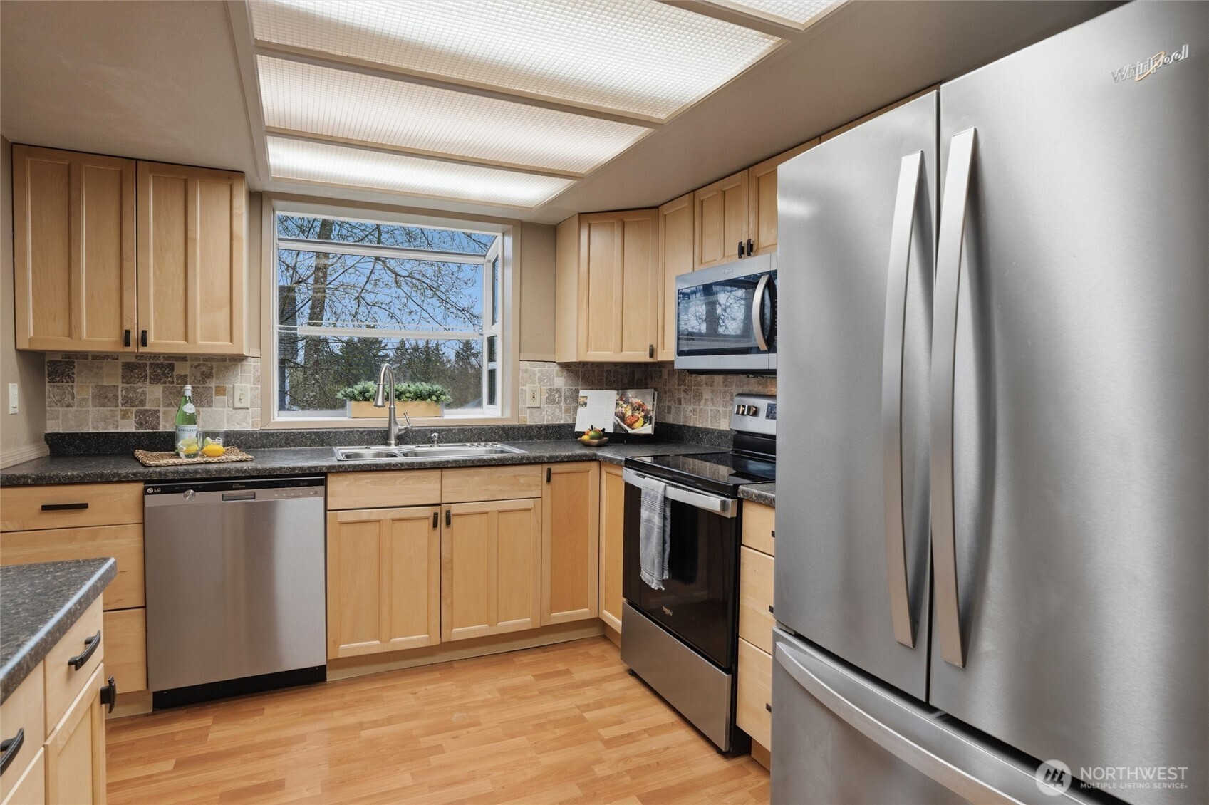 19855 Stavanger Loop Northeast Poulsbo, WA 98370 - Photo 10 of 37 a kitchen with stainless steel appliances granite countertop a refrigerator sink and stove