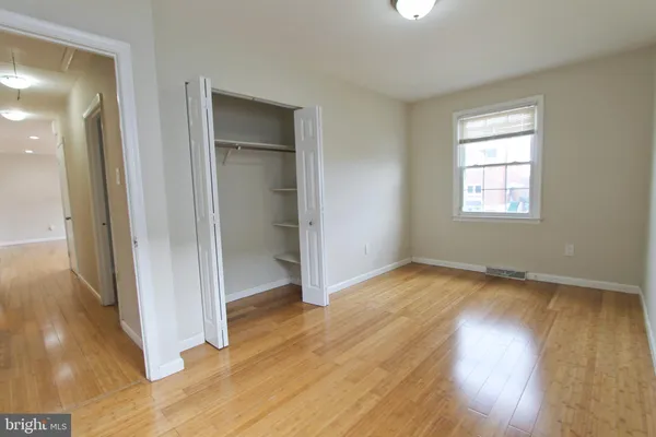 an empty room with wooden floor and a window