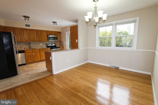 a kitchen with stainless steel appliances kitchen island granite countertop a refrigerator stove top oven and sink