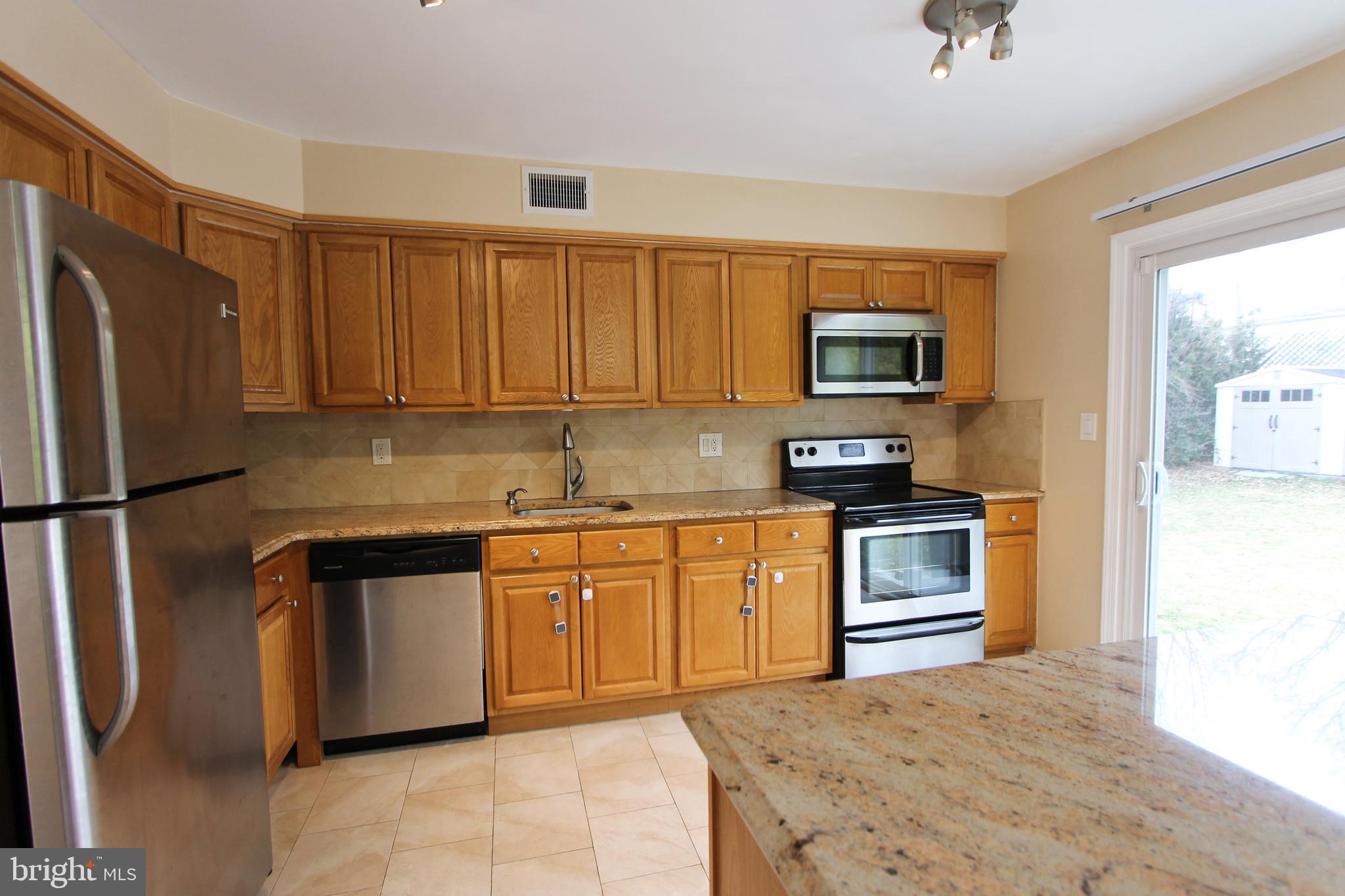 617 Renz Street Philadelphia, PA 19128 - Photo 20 of 28 a kitchen with granite countertop a refrigerator stove and microwave