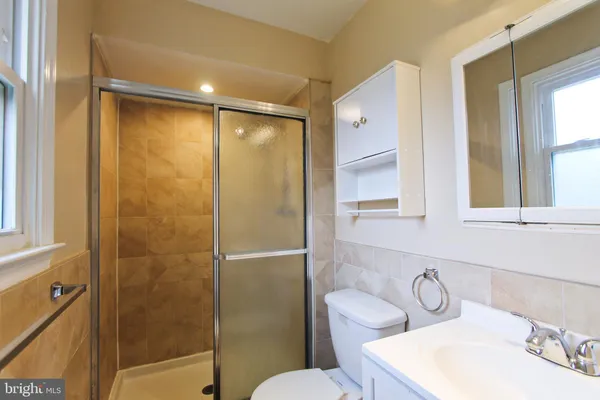 a bathroom with a sink and mirror with toilet