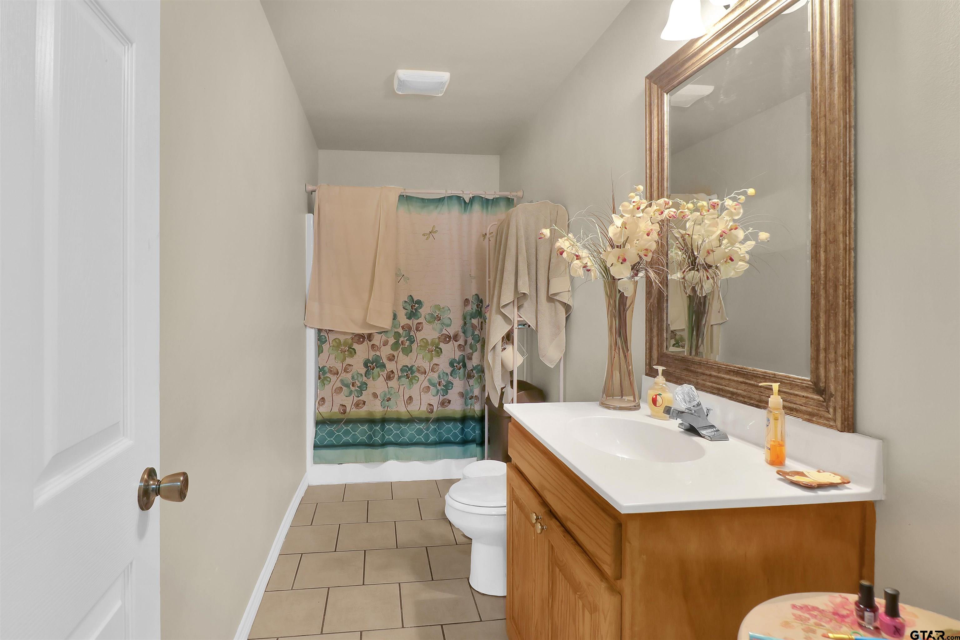 1224 West 3rd Street Tyler, TX 75701 - Photo 7 of 14 a bathroom with a sink a toilet and shower