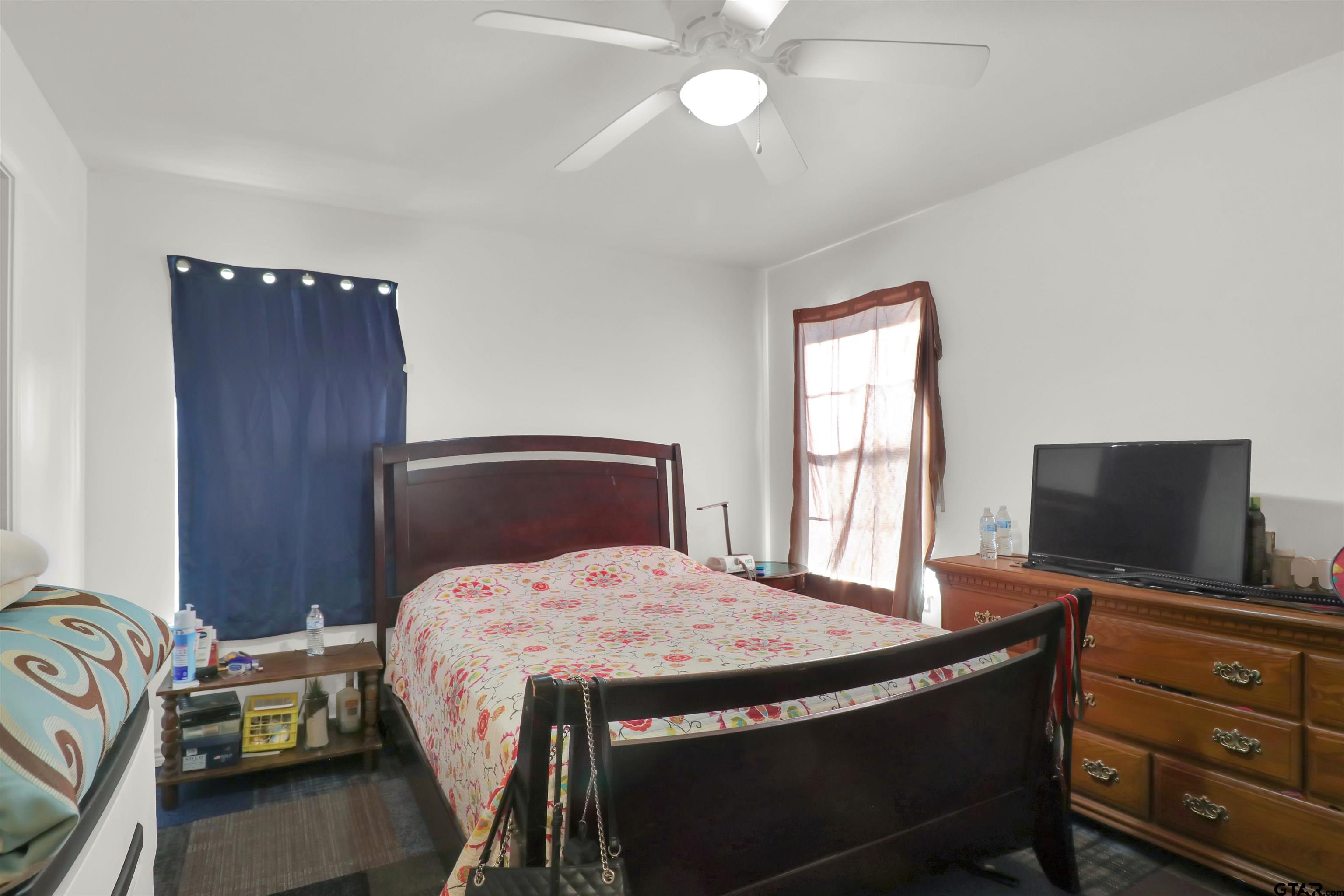 1224 West 3rd Street Tyler, TX 75701 - Photo 10 of 14 a bedroom with a bed and a flat screen tv
