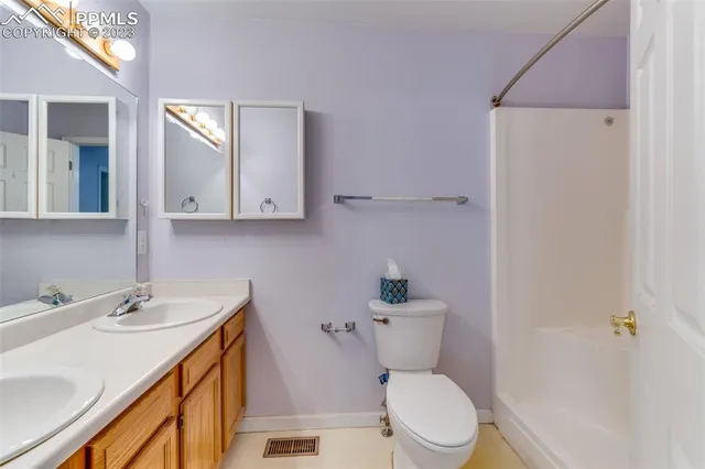 a white toilet sitting next to a bathroom sink and tub