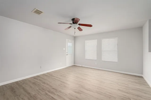 a view of room with hardwood floor and ceiling fan